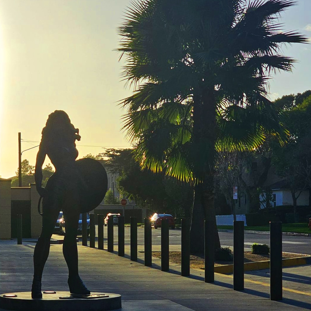 Wonder Woman statue and a palm tree outside Warner Bros. Studios.